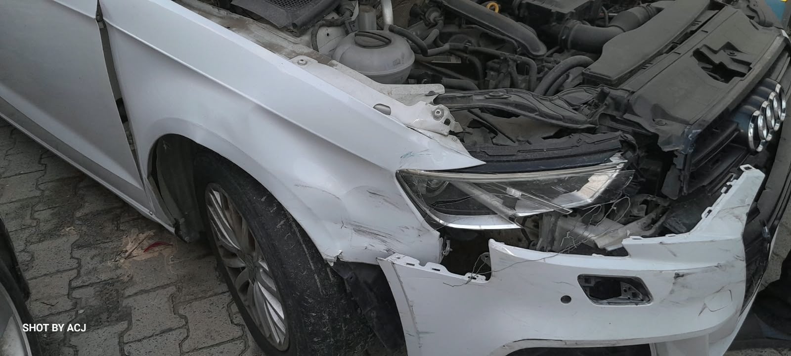 White Audi crumpled front wing and bumper before repair
