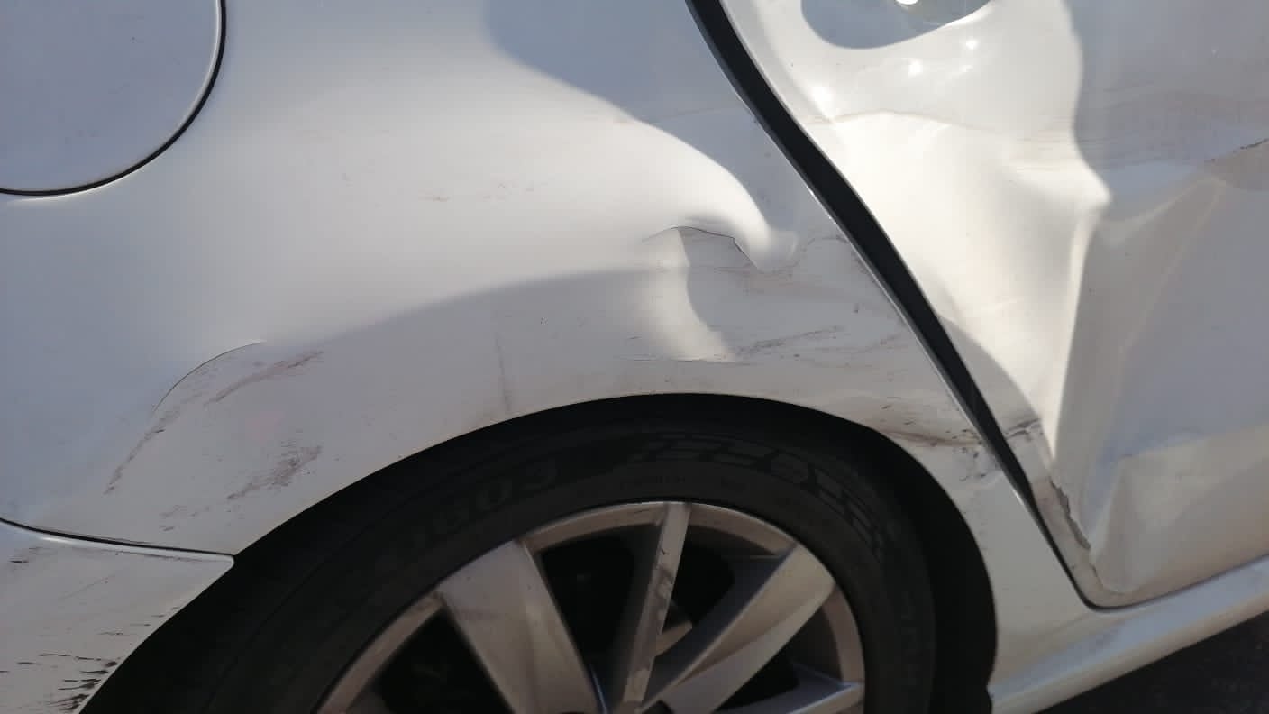 White Volkswagen Polo rear quarter panel damage before repair